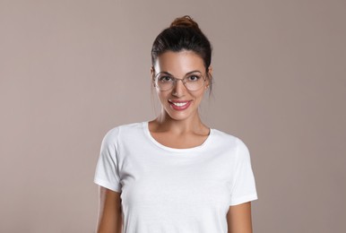 Beautiful woman in eyeglasses on light brown background