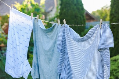Shirts drying on washing line outdoors. Clean clothes