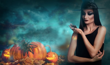 Young girl dressed as witch with creepy spider in misty forest at night. Halloween fantasy