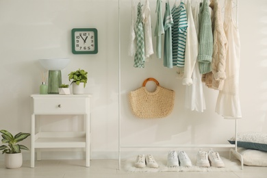 Dressing room interior with clothing rack and nightstand