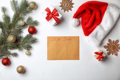 Flat lay composition with childish letter to Santa Claus and Christmas decoration on white background