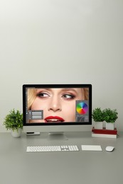 Designer's workplace. Computer with photo editor application on table 