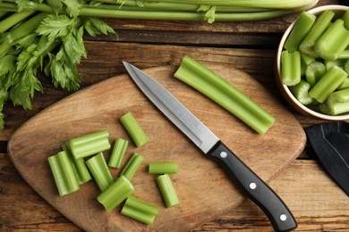 Fresh ripe green celery on wooden table, flat lay