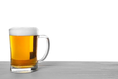 Glass mug of tasty beer on wooden table against white background