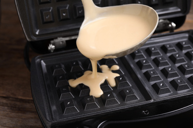 Photo of Pouring dough onto Belgian waffle maker, closeup