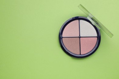 Photo of Colorful contouring palette on light green background, top view with space for text. Professional cosmetic product