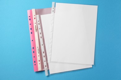 Photo of File folder with punched pockets on light blue background, flat lay