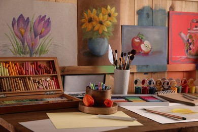 Artist's workplace with drawing, soft pastels and color pencils on table