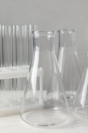 Photo of Set of laboratory glassware on white table against grey background