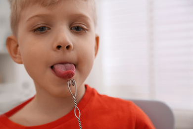 Little boy doing exercise with logopedic probe at speech therapist office, closeup