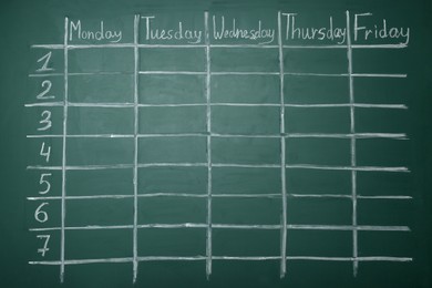 Weekly school timetable drawn on green chalkboard