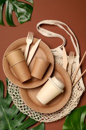 Flat lay composition with disposable tableware on brown background