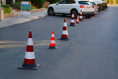 Traffic cones near cars on asphalt outdoors