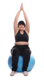 Happy overweight mature woman sitting on fitness ball against white background