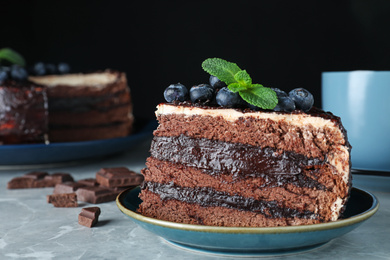 Tasty chocolate cake with berries on grey marble table