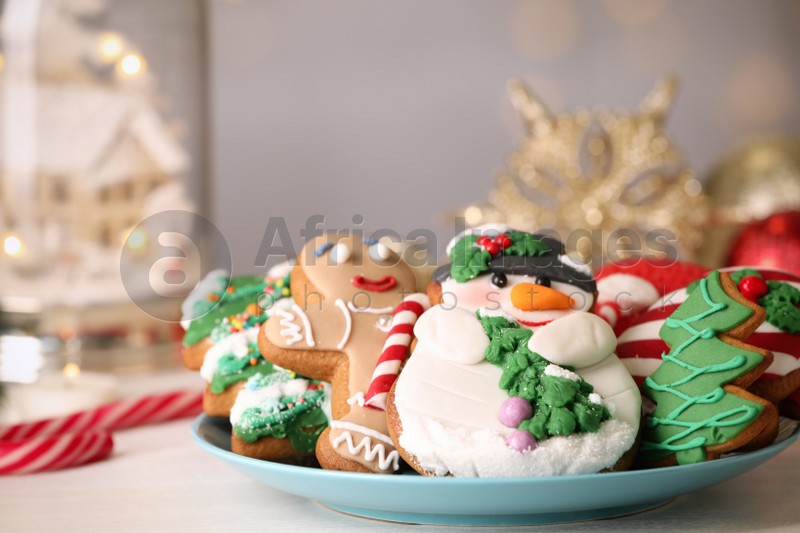 Sweet Christmas cookies on white table against blurred festive lights, closeup