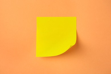 Photo of Blank paper note on pale orange background, top view