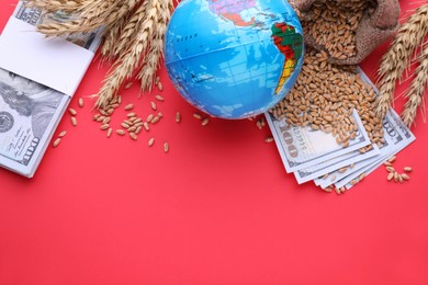 Import and export concept. Globe, ears of wheat and money on red background, flat lay with space for text