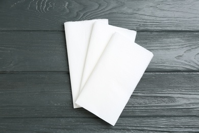 Clean napkins on grey wooden table, flat lay