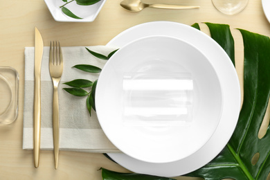 Elegant table setting with green tropical leaves, flat lay