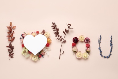 Phrase I Love You made of flowers and paper heart on beige background, flat lay