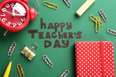 Photo of Alarm clock, text HAPPY TEACHER'S DAY and stationery on color paper