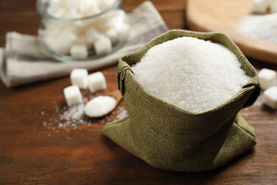 Granulated sugar in sack on wooden table