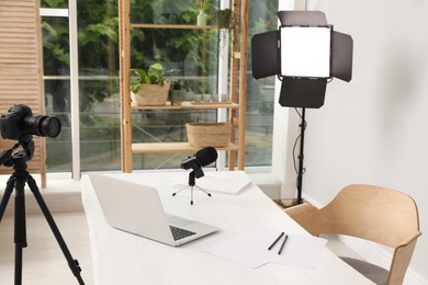 Modern blogger's workplace with professional equipment and laptop in room