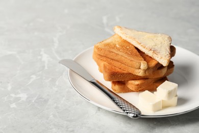 Tasty toasts with butter served on grey marble table. Space for text
