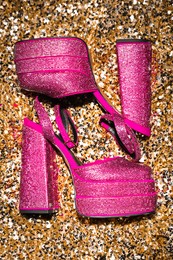 Photo of Fashionable punk square toe ankle strap pumps on golden sequins, top view. Shiny party platform high heeled shoes