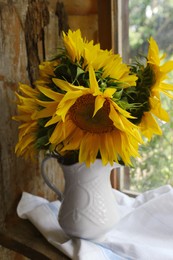 Beautiful sunflowers in vase near window indoors