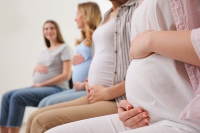 Group of pregnant women at courses for expectant mothers indoors, closeup