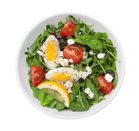 Photo of Delicious salad with boiled egg, tomatoes and cheese in bowl isolated on white, top view
