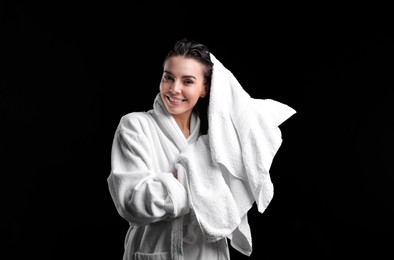 Pretty woman drying hair with towel after washing on black background