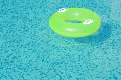 Light green inflatable ring floating in swimming pool. space for text