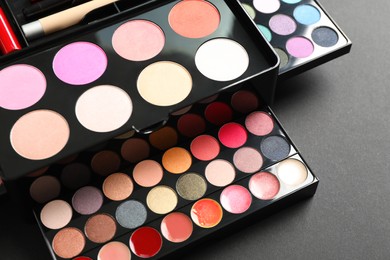 Photo of Large makeup case with different decorative cosmetics on dark background