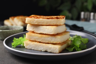 Delicious turnip cake with lettuce salad served on grey table, closeup