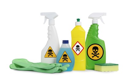 Photo of Bottles of toxic household chemicals with warning signs, gloves and scouring sponge on white background