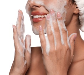 Beautiful woman applying facial cleansing foam on white background, closeup