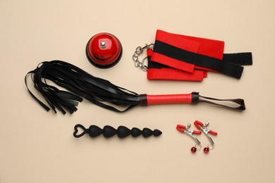 Photo of Sex toys and accessories on beige background, flat lay