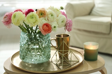Beautiful ranunculus flowers in vase on wooden table indoors