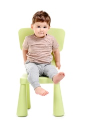 Photo of Cute baby sitting on chair against white background