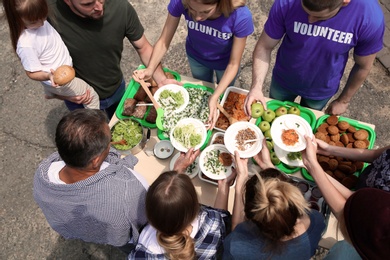 Volunteers serving food for poor people outdoors, above view