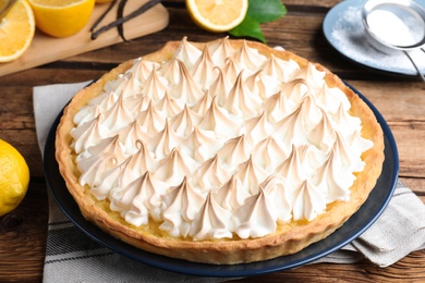 Delicious lemon meringue pie on wooden table, closeup