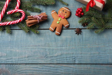 Flat lay composition with gingerbread man on blue wooden table, space for text