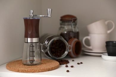 Manual coffee grinder on shelf in kitchen