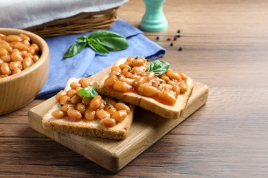 Toasts with delicious canned beans on wooden table