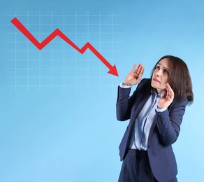 Worried businesswoman and illustration of falling down chart on light blue background. Economy recession concept