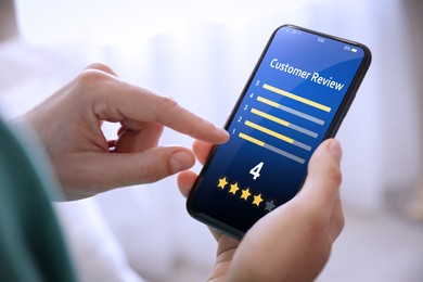 Man using smartphone to give feedback indoors, closeup. Customer review