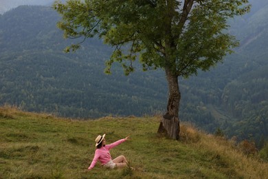 Photo of Beautiful young woman enjoying picturesque mountain landscape